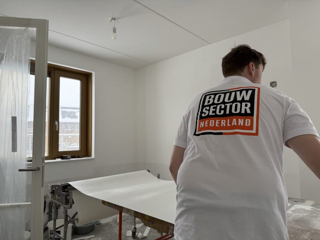 Behanger van Bouwsector Nederland trekt een baan renovlies van de plaktafel