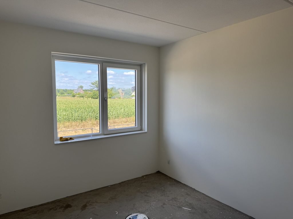 Gesausde wand in een nieuwbouwkamer waar het daglicht schuin langs valt